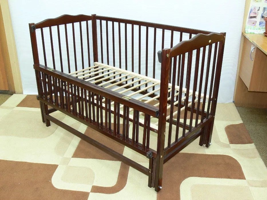 Кроватка для новорожденного с маятником красноватого оттенка